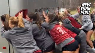 Women's lacrosse team pushes bus stuck in the mud
