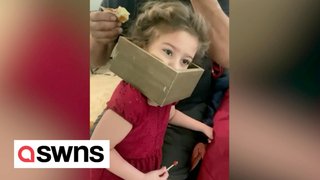 Funny moment 5-year-old girl gets box shelf stuck on her head after using it as crown